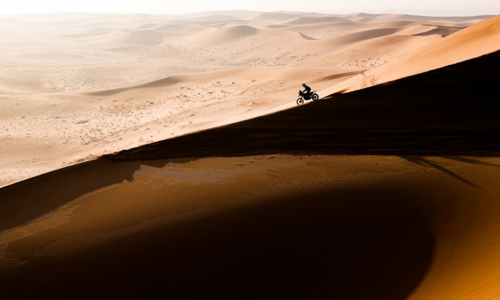 Stefan Svitko of the Slovnaft Rally Team, is caught against the morning sun as he rides along the ridge of a dune on his KTM 450 Rally during Stage 3 (F.Gooden - DPPI/ASO).