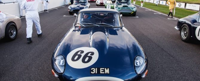 A Jaguar E-Type on the grid surrounded by more E-Types, Aston Martin DB4 GTs and Ferrari 250 GT SWBs