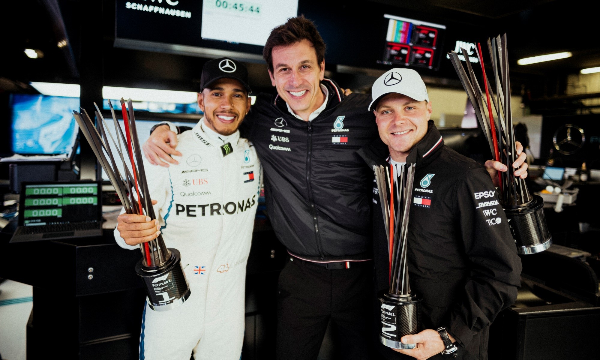 Mercedes F1 team mates celebrate with team boss Toto Wolff