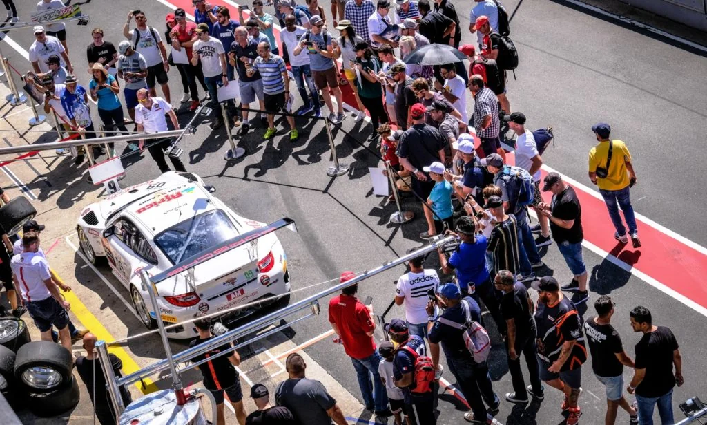 The Team Perfect Circle Porsche surrounded by fans on the Friday pit walk