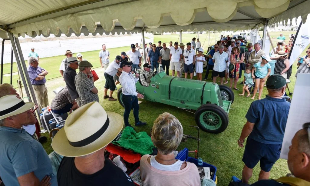 The gathered crowds learn more about the history of each car